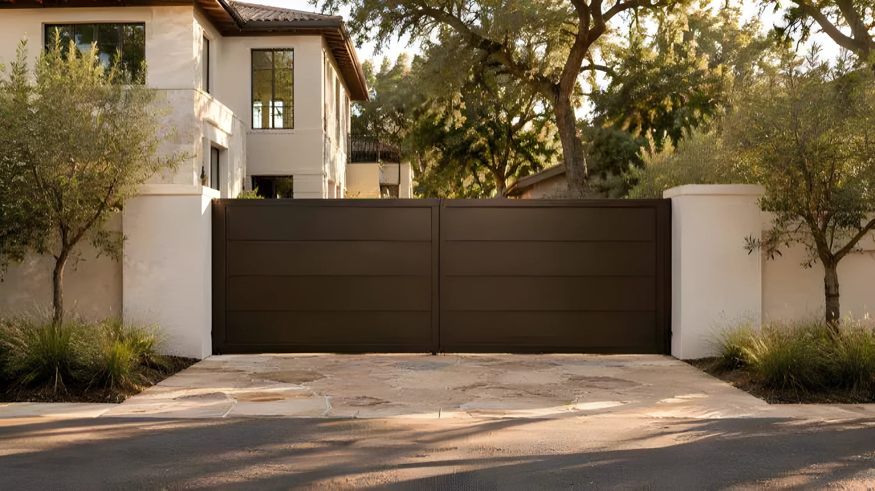 Wood-grain aluminum driveway gate between stone columns