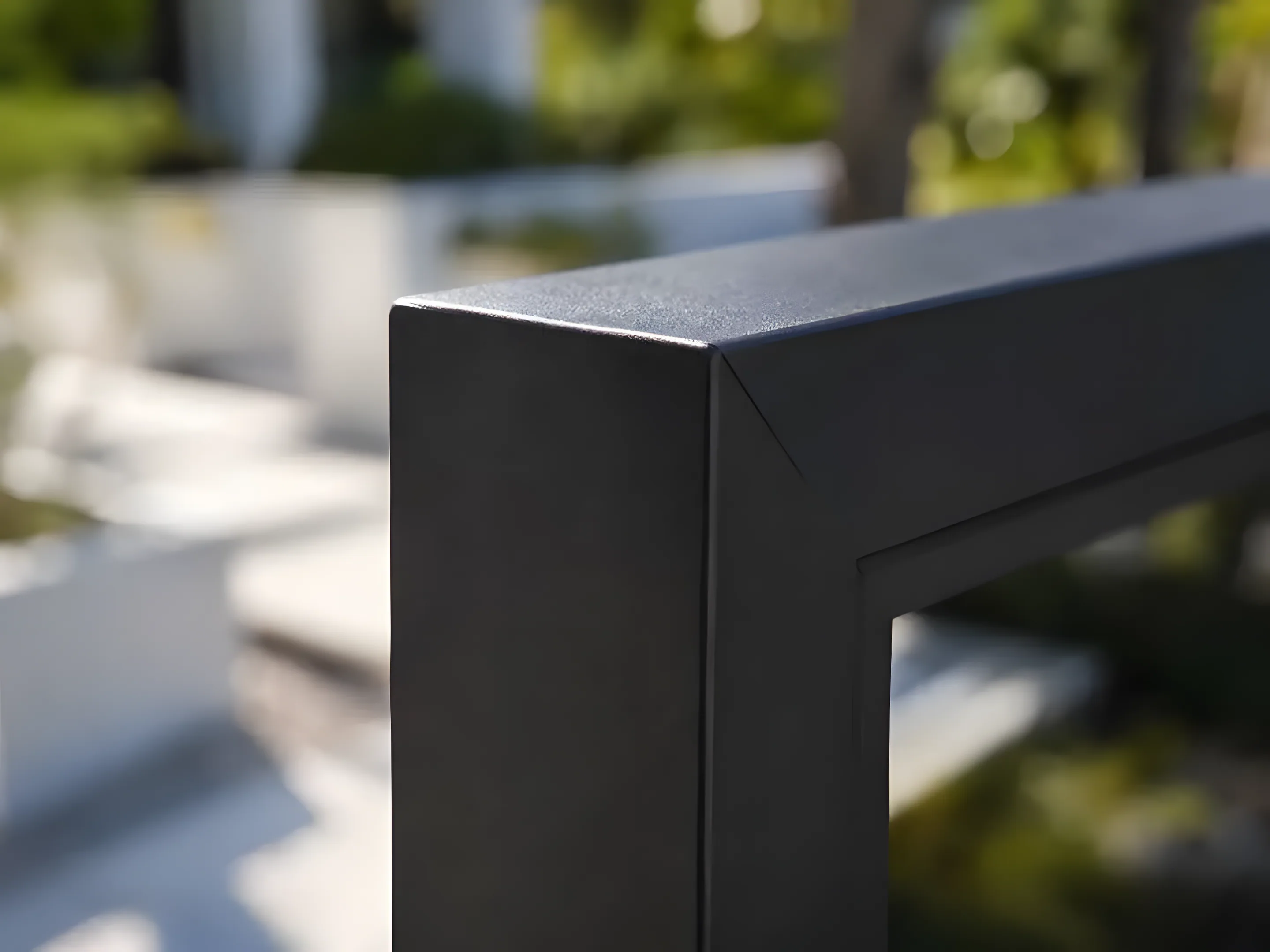Close-up of a dark aluminum gate frame corner