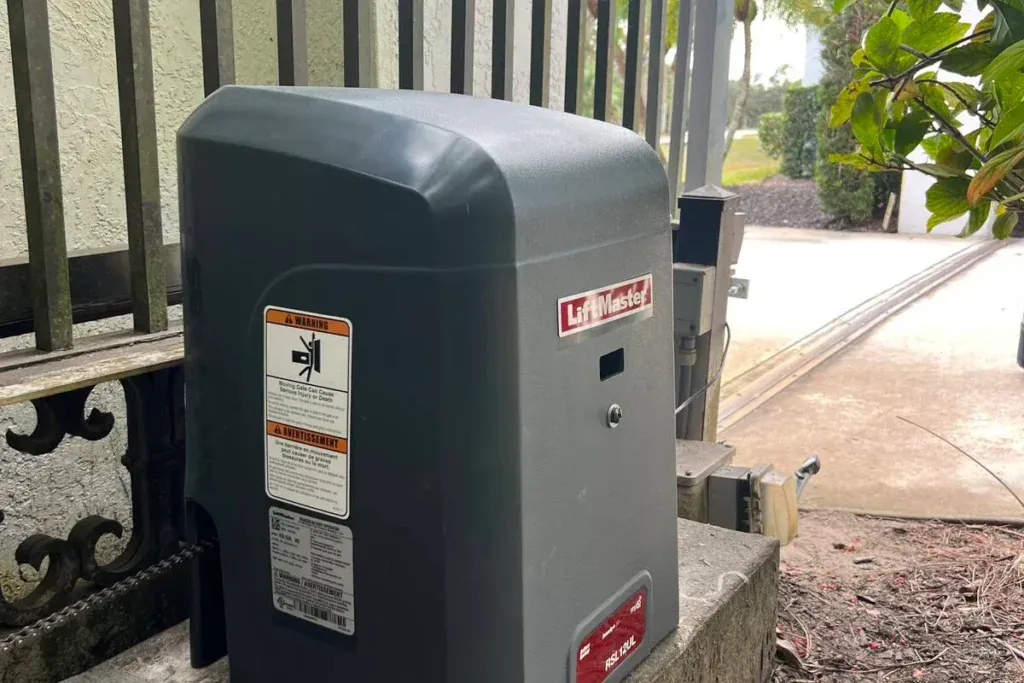 Automatic Gate Repair That Keeps Boca Del Mar Moving LiftMaster slide gate opener mounted beside a metal fence