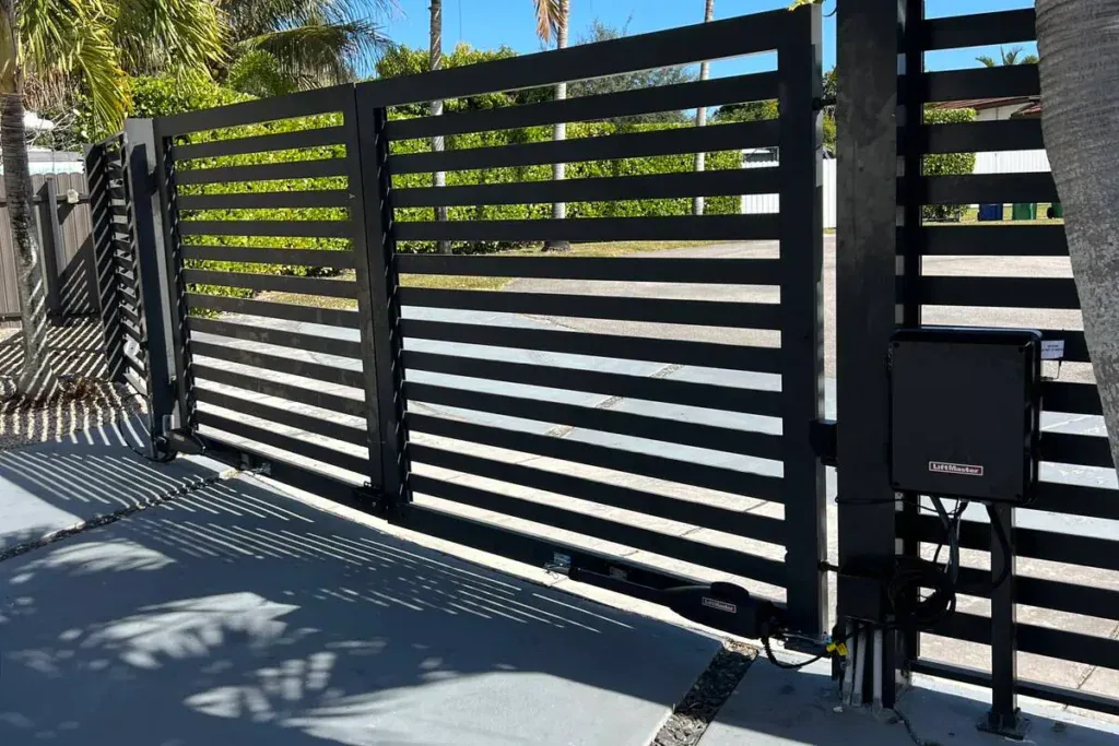 Black horizontal-slat aluminum gate with a LiftMaster opener