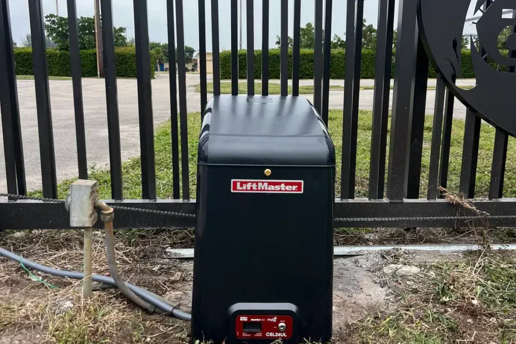 LiftMaster slide gate operator at the base of a black metal fence